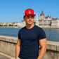Male model wearing red Hungarian coat of arms trucker hat in Budapest
